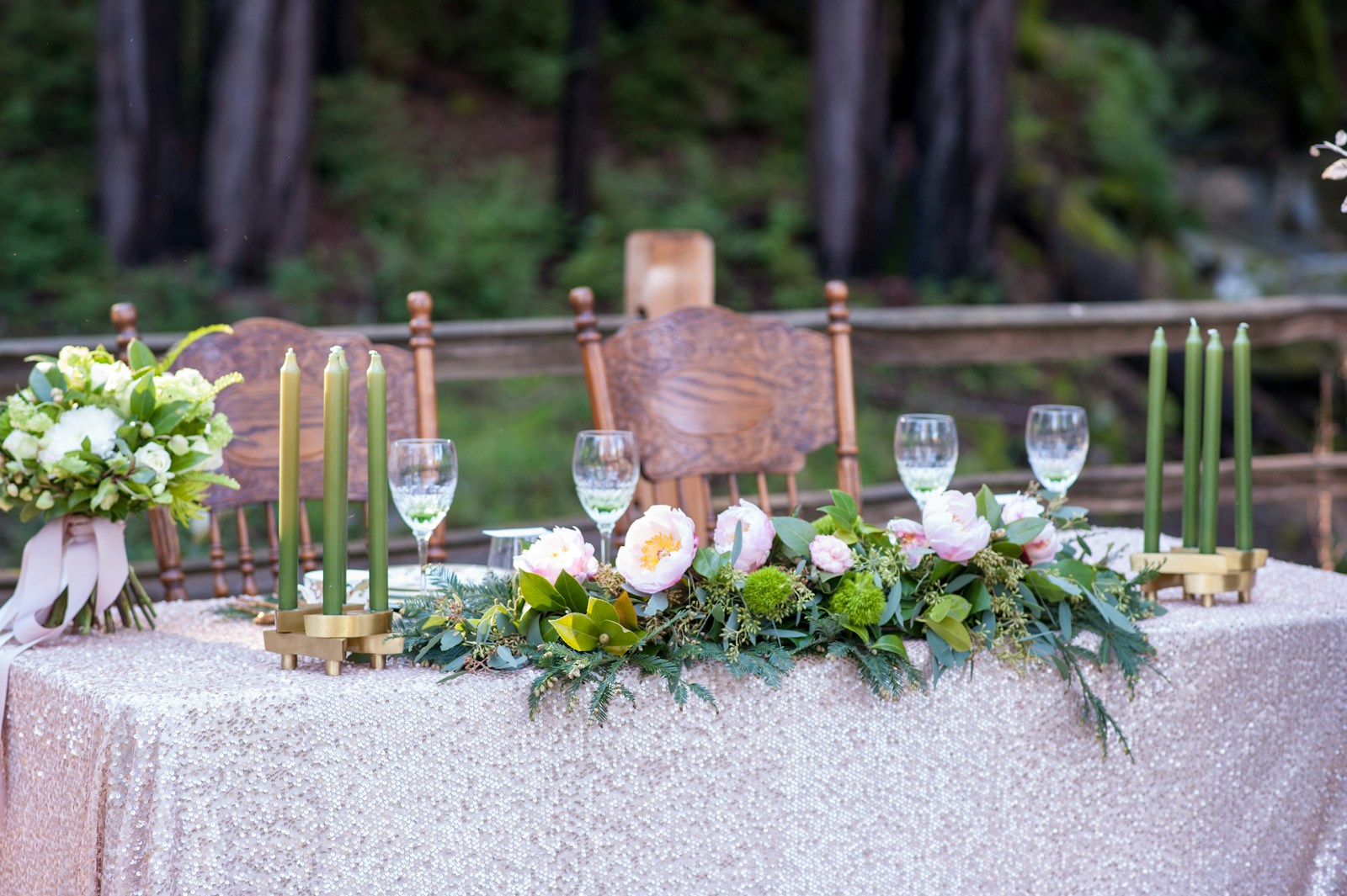 A candlelit outdoor table set with flowers and glassware